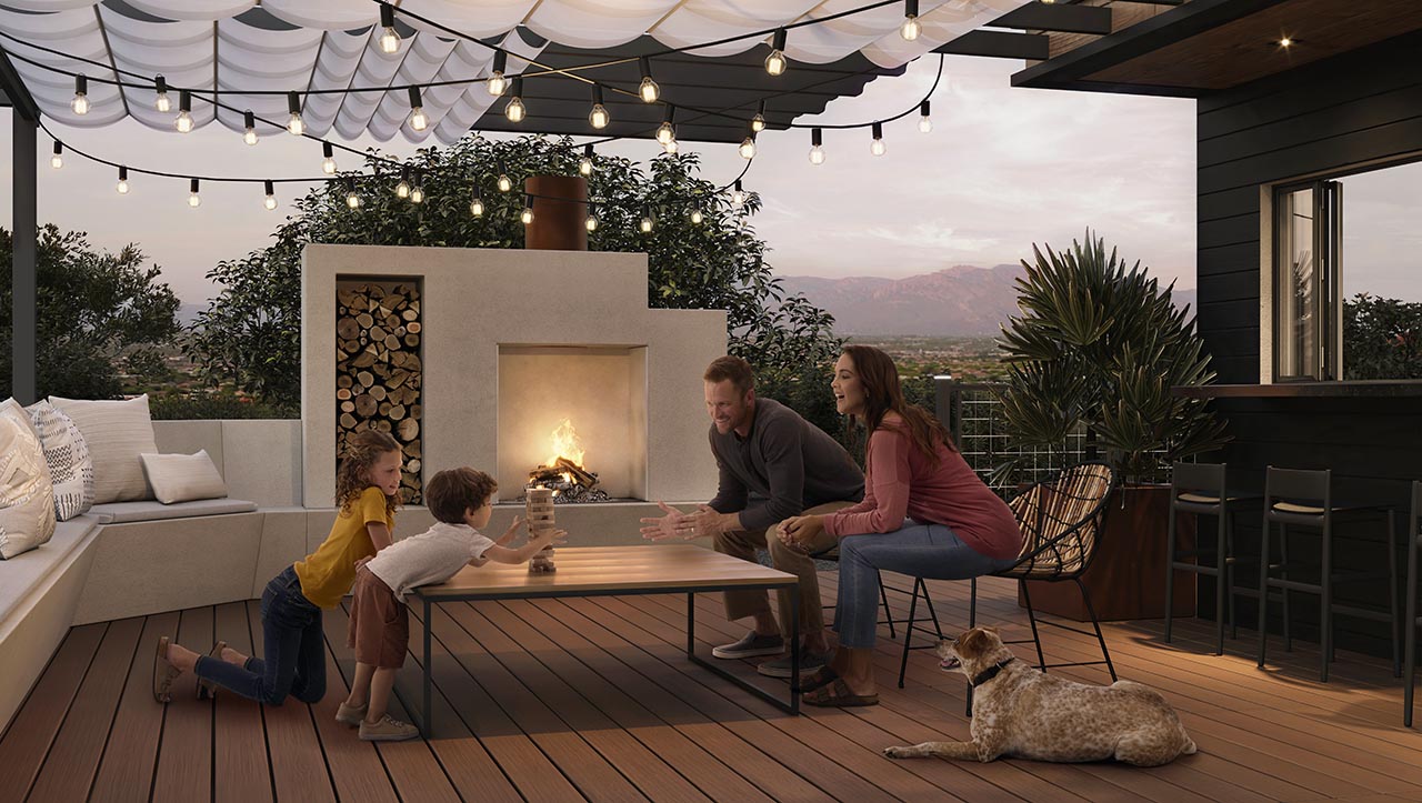 sig-arizona-011-oc-sig-mesh-railing-pergola-family-fireplace-dusk.tif A family around table playing jenga next to a fire pit table on their deck, made of Trex Signature Ocracoke. It is night and lights are set up across the deck to create a warm and calming feeling.